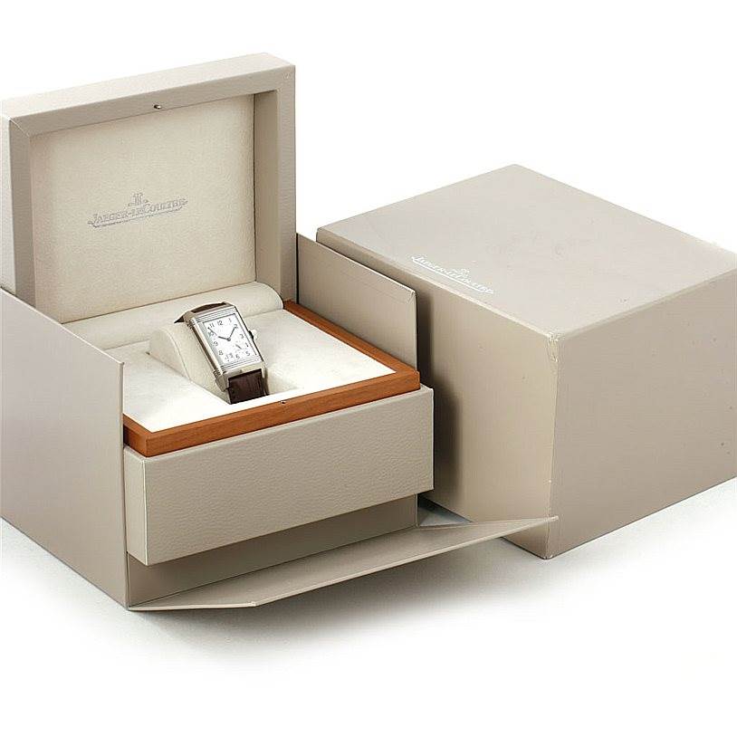 This image shows a Jaeger LeCoultre Reverso 240.8.15 Men's Stainless Steel Silver Dial 240.8.15 Men's Stainless Steel Silver Dial watch in its open, beige display box, with the outer packaging partially open.