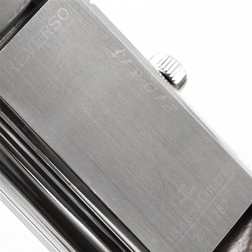 The image showcases a close-up of the side and back of a Jaeger LeCoultre Reverso 240.8.15 Men's Stainless Steel Silver Dial 240.8.15 Men's Stainless Steel Silver Dial watch, highlighting the crown and the engraved back panel.