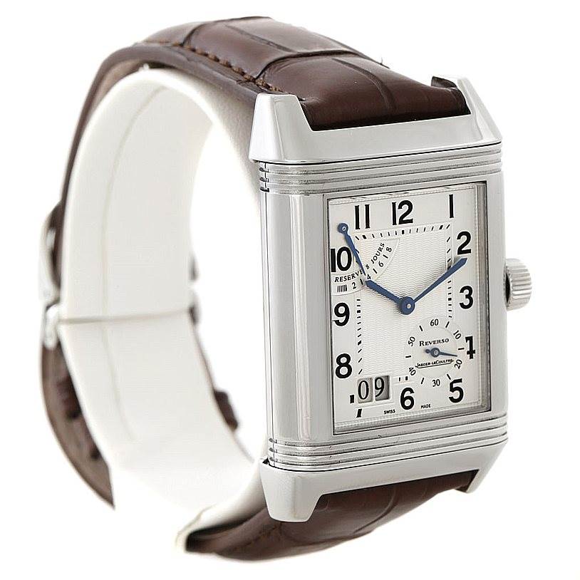 The image shows a Jaeger-LeCoultre Reverso watch at a 3/4 angle, featuring a brown leather strap and a detailed dial.