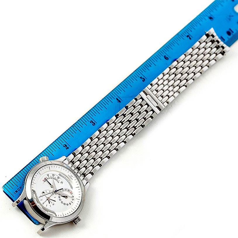 The image shows a Jaeger LeCoultre Master 142.8.92 Men's Stainless Steel Silver Dial 142.8.92 Men's Stainless Steel Silver Dial model watch, viewed from an oblique angle, displaying its face and metal bracelet adjacent to a ruler.