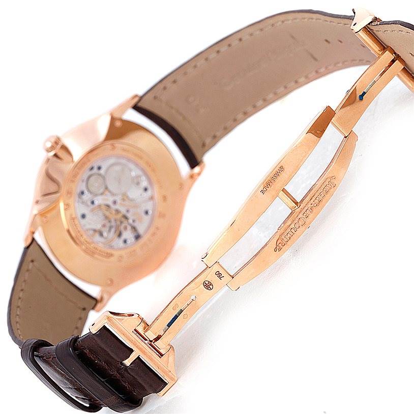 The image shows the back view and inner mechanics of the Jaeger LeCoultre Master 142.2.92 Men
s Rose Gold Brown Dial 142.2.92 Men
s Rose Gold Brown Dial model watch, along with its partially open strap and clasp.