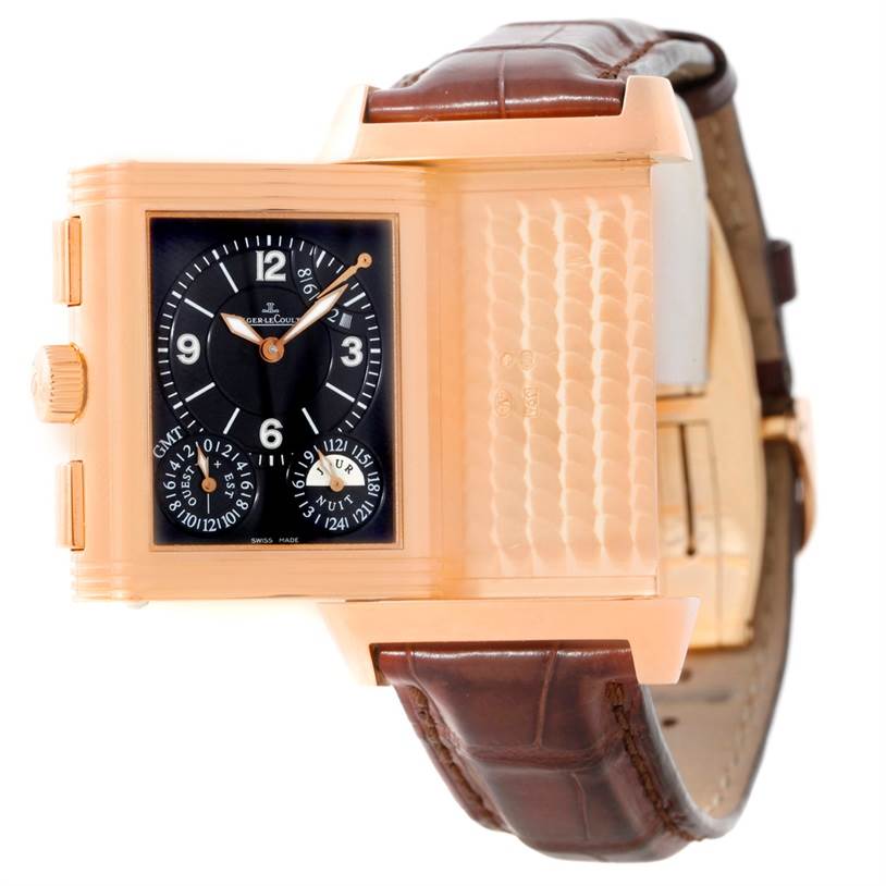 This Jaeger-LeCoultre Reverso watch is shown at an angle revealing its brown leather strap, gold case, and black dial with multiple subdials.