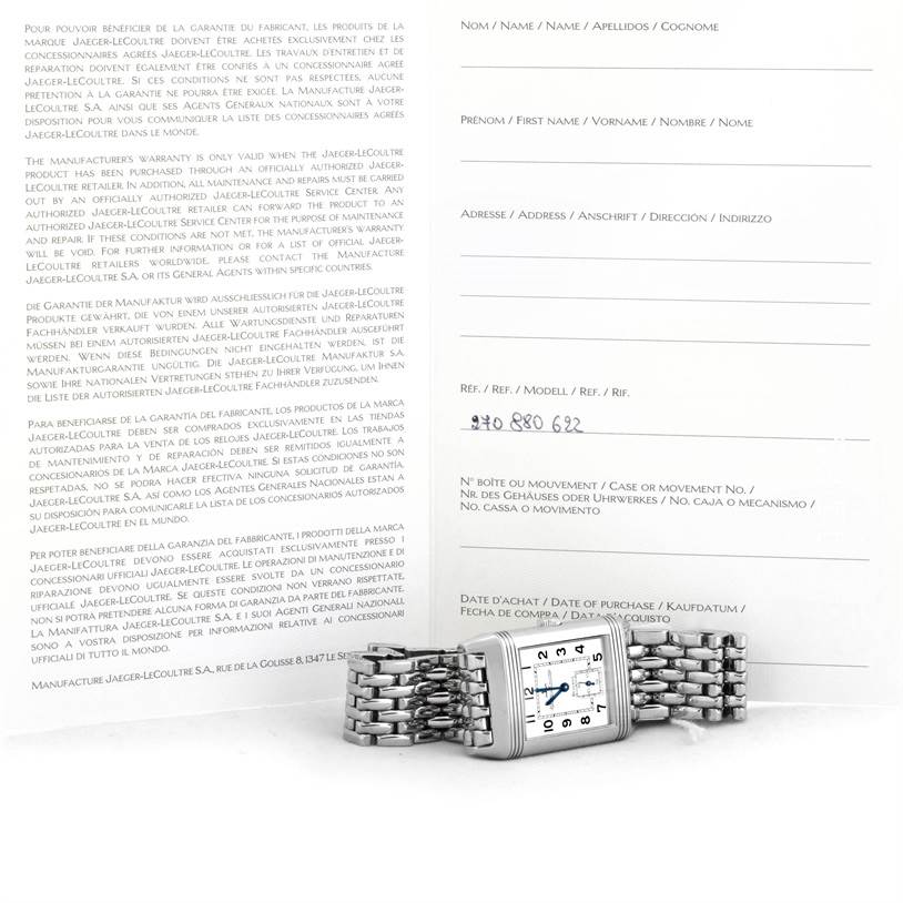 The image shows a Jaeger LeCoultre Reverso 270.8.62 Men's Stainless Steel Silver Dial 270.8.62 Men's Stainless Steel Silver Dial watch lying flat with its bracelet spread out, alongside its warranty card.