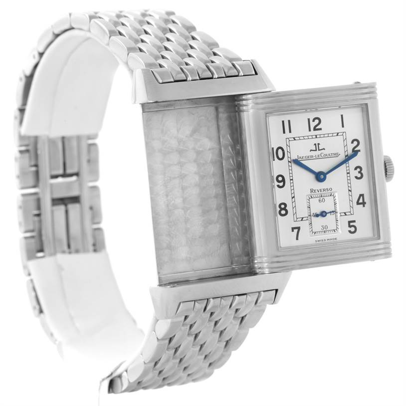 The image shows a Jaeger-LeCoultre Reverso watch with a rotated case displaying its reverse side and a stainless steel bracelet.