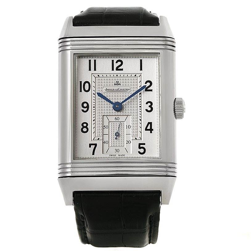 The Jaeger-LeCoultre Reverso watch is shown from a front angle, displaying its dial, case, crown, and black strap.