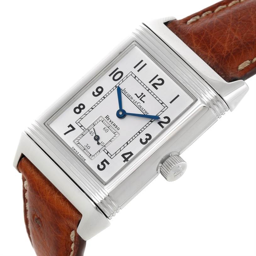 The Jaeger LeCoultre Reverso 2708410 Men
s Stainless Steel Silver Dial 2708410 Men
s Stainless Steel Silver Dial watch is shown from an angle highlighting the face, blue hands, and brown leather strap.
