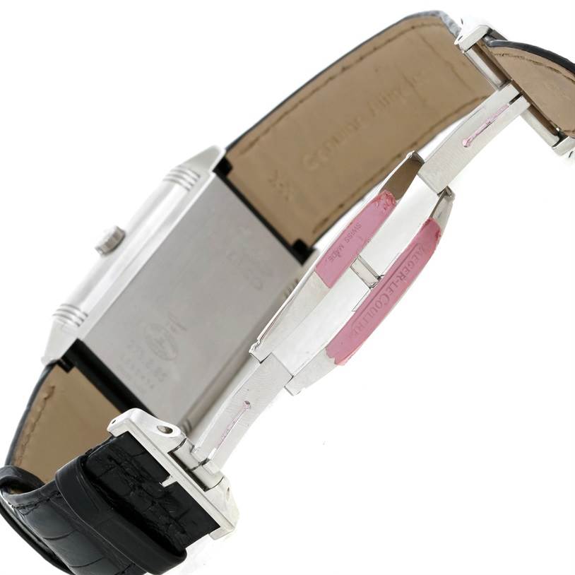 The Jaeger-LeCoultre Reverso watch is shown from the side, highlighting the reverse side of the case, the crown, and part of the leather strap.