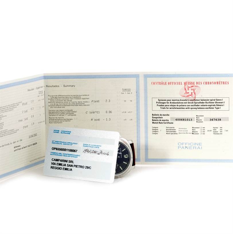 The image shows the Panerai Luminor PAM00090 Men
s Stainless Steel Black Dial PAM00090 Men
s Stainless Steel Black Dial watch partially with documentation and a warranty card displayed.