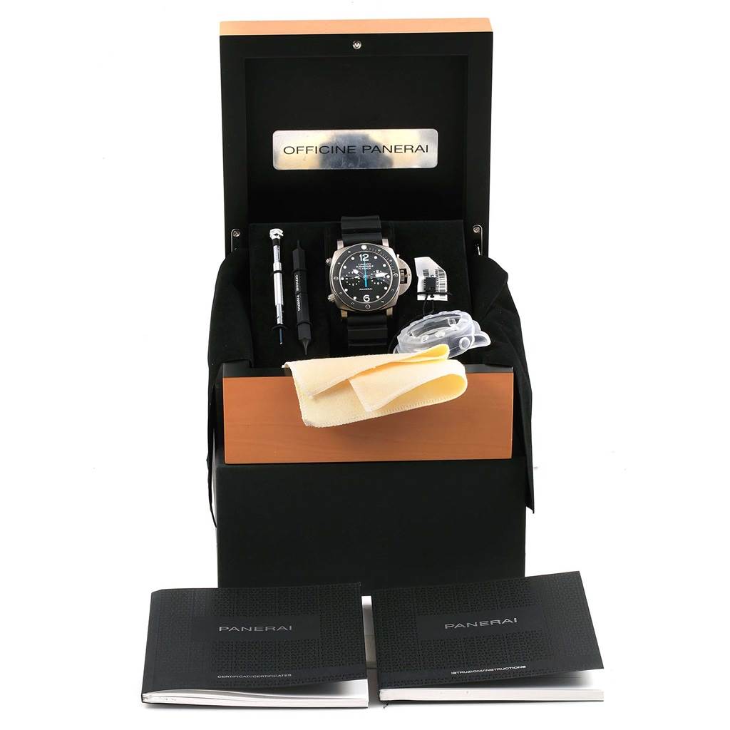 The image shows a Panerai Submersible PAM00615 Men's Titanium Black Dial PAM00615 Men's Titanium Black Dial watch and its accessories from a front angle, including tools, booklets, and a cleaning cloth.