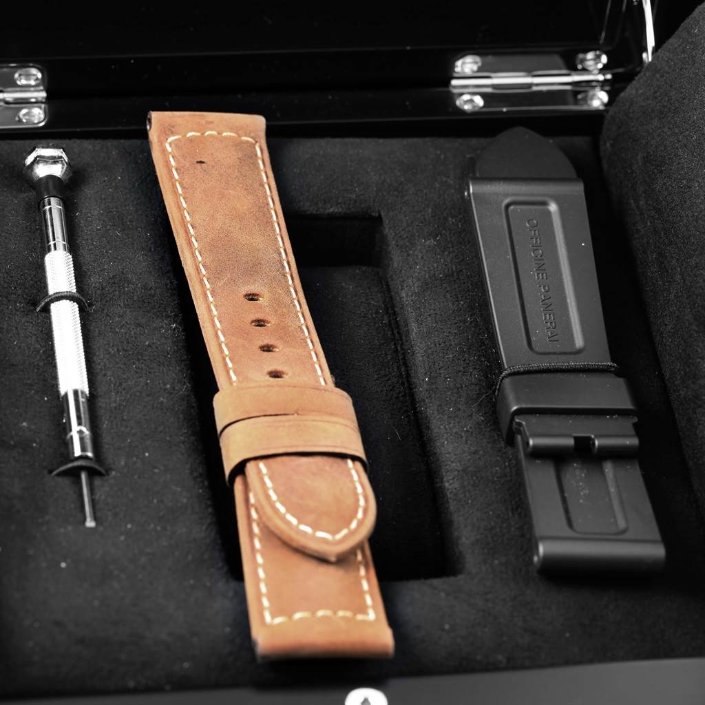 The image shows a Panerai Luminor PAM00724 Men's Stainless Steel Black Dial PAM00724 Men's Stainless Steel Black Dial watch accessory set, including a brown leather strap, a black rubber strap, and a screwdriver.