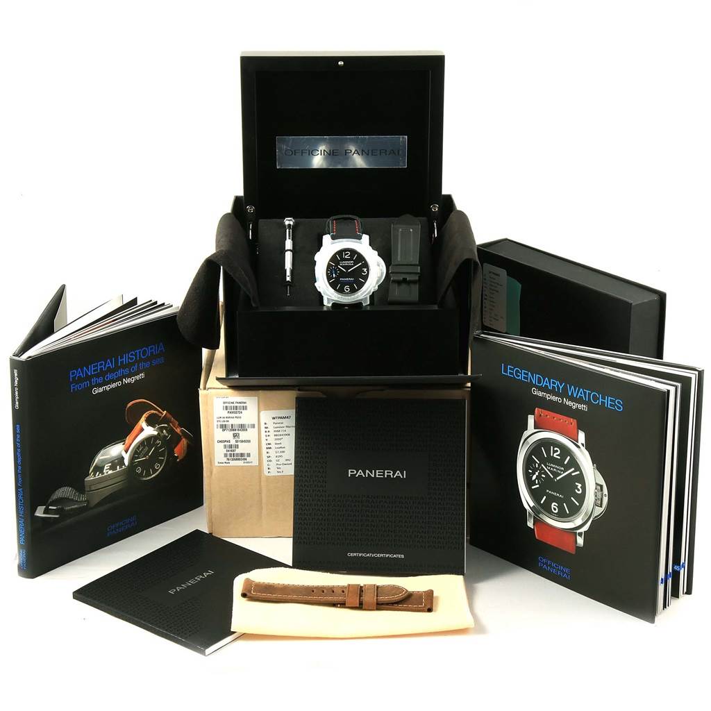 The image shows a Panerai Luminor PAM00724 Men's Stainless Steel Black Dial PAM00724 Men's Stainless Steel Black Dial watch set displayed frontally, including the watch in its box, tools, books, and an extra strap.