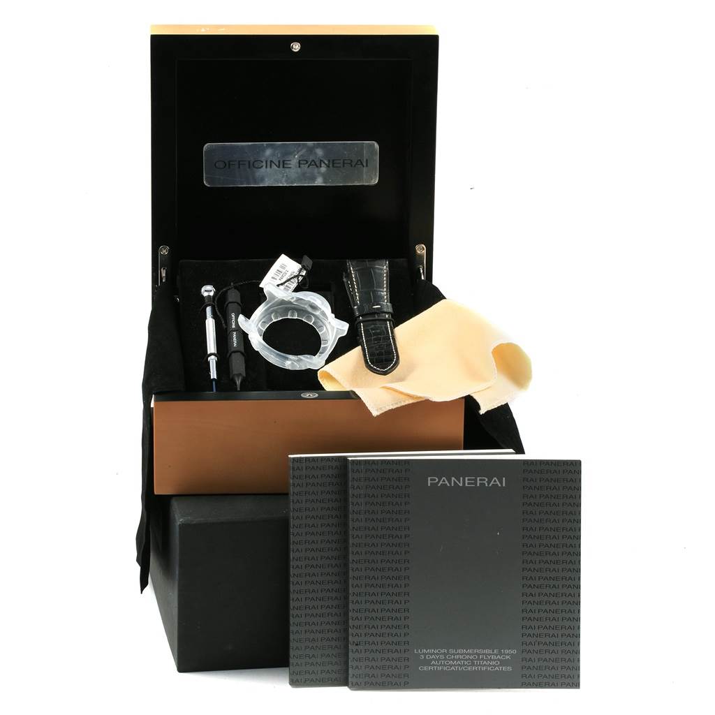 The image shows an open box with accessories for the Panerai Submersible PAM00614 Men's Titanium Black Dial PAM00614 Men's Titanium Black Dial model, including tools, a strap, and documentation.