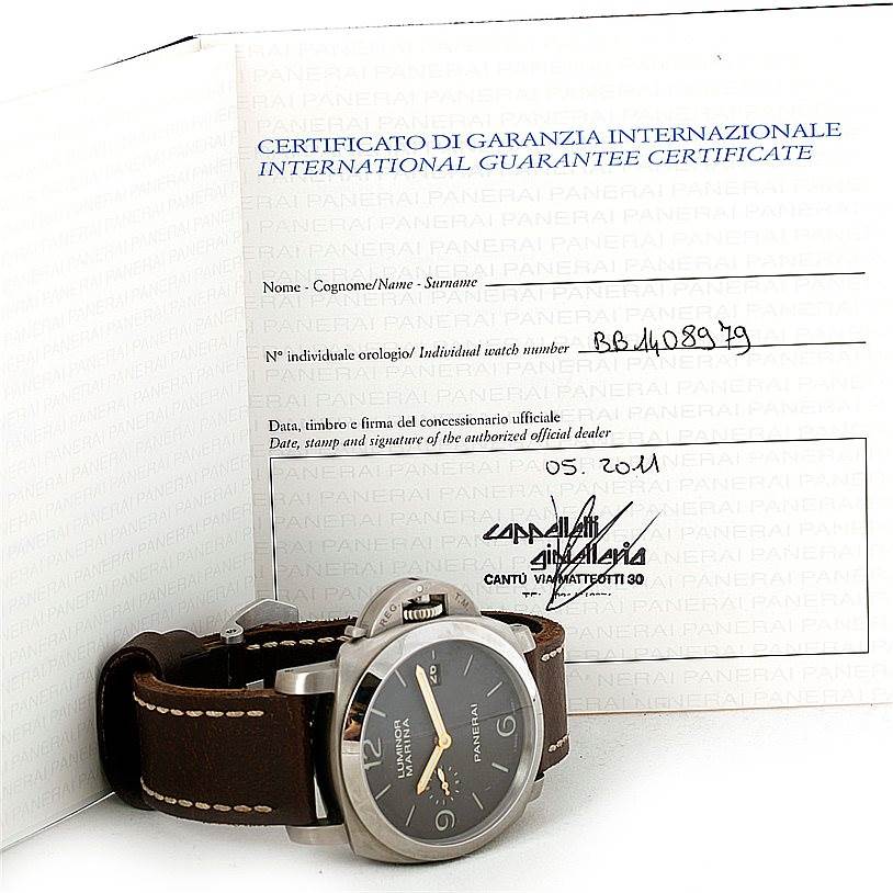 The Panerai Luminor PAM00351 Men's Titanium Brown Dial PAM00351 Men's Titanium Brown Dial watch is shown from a side angle, displaying the case, dial, crown guard, and leather strap, with a warranty certificate in the background.