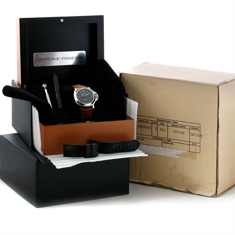 The image shows a Panerai Luminor PAM00112 Men
s Stainless Steel Black Dial PAM00112 Men
s Stainless Steel Black Dial watch with its box, extra strap, tools, and packaging from an angled front view.
