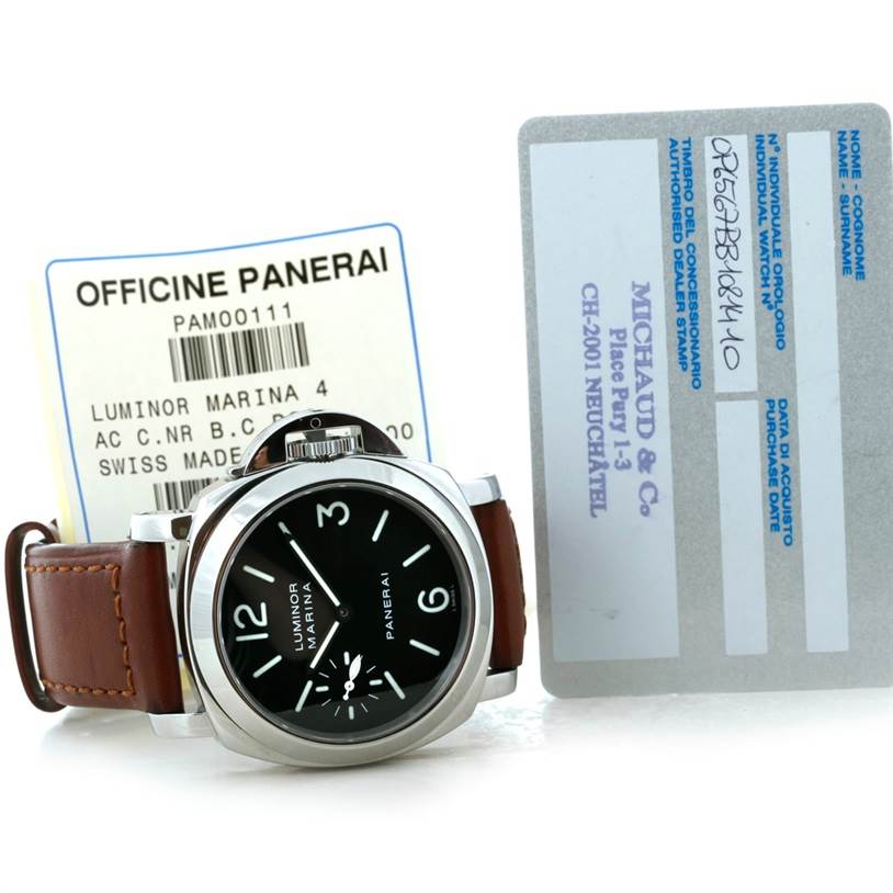The Panerai Luminor PAM00111 Men's Stainless Steel Black Dial PAM00111 Men's Stainless Steel Black Dial watch is displayed front-facing with accompanying documents in the background.