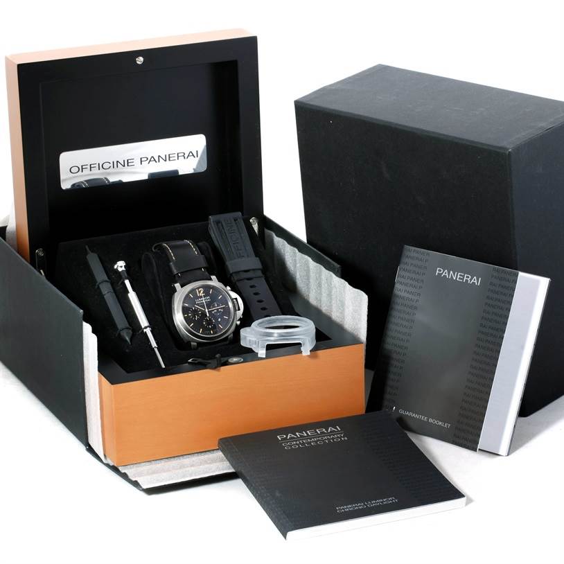 The Luminor model by Panerai is shown in its box with accessories, including a tool, extra strap, and booklets from a top angle.