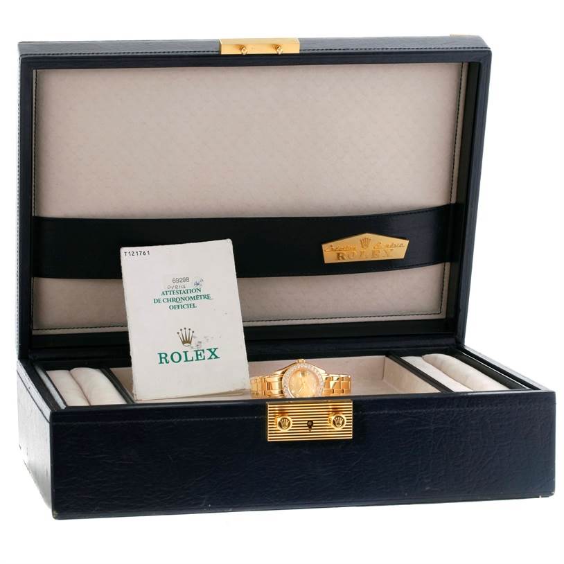 The image shows a Rolex Pearlmaster 69298 Women's Yellow Gold Champagne Dial 69298 Women's Yellow Gold Champagne Dial watch inside an open display box with a certificate booklet.