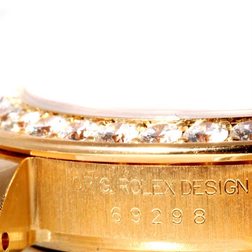 The image shows a close-up angle of the Rolex Pearlmaster 69298 Women's Yellow Gold Champagne Dial 69298 Women's Yellow Gold Champagne Dial watch bezel with diamonds and the engraved model number "69298".