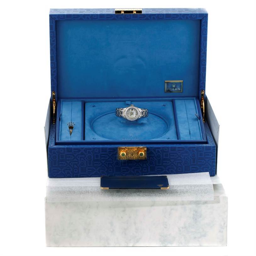 The image shows a Rolex Pearlmaster 80299 Women
s White Gold Mother of Pearl Dial 80299 Women
s White Gold Mother of Pearl Dial watch placed inside an open blue presentation box with compartments and tools.