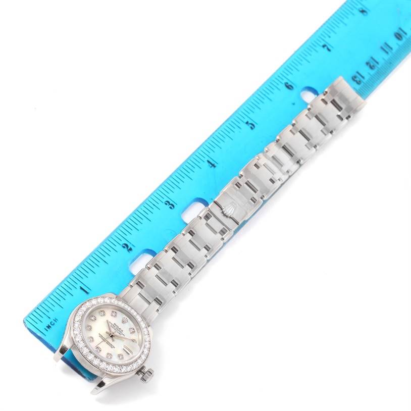 The Rolex Pearlmaster 80299 Women's White Gold Mother of Pearl Dial 80299 Women's White Gold Mother of Pearl Dial watch is shown from a top-down angle, displaying its face, bracelet, and a measurement ruler alongside it.