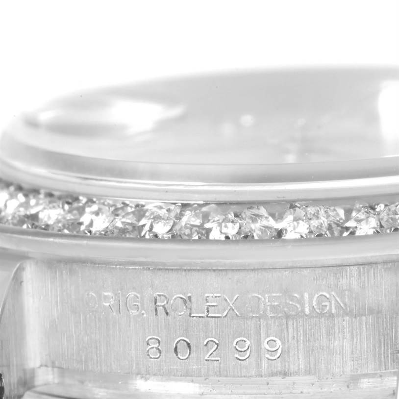 The image shows a close-up of the bezel adorned with diamonds and the engraved serial number of a Rolex Pearlmaster 80299 Women's White Gold Mother of Pearl Dial 80299 Women's White Gold Mother of Pearl Dial watch.