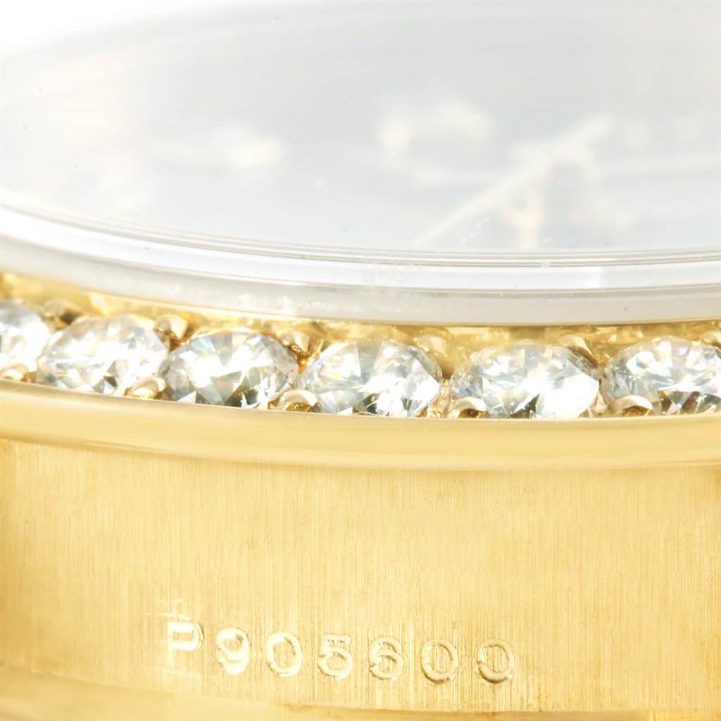 This close-up image shows the side of a Rolex Pearlmaster 80298 Women's Yellow Gold Silver Dial 80298 Women's Yellow Gold Silver Dial watch, highlighting the diamond-set bezel and part of the gold case with a serial number.