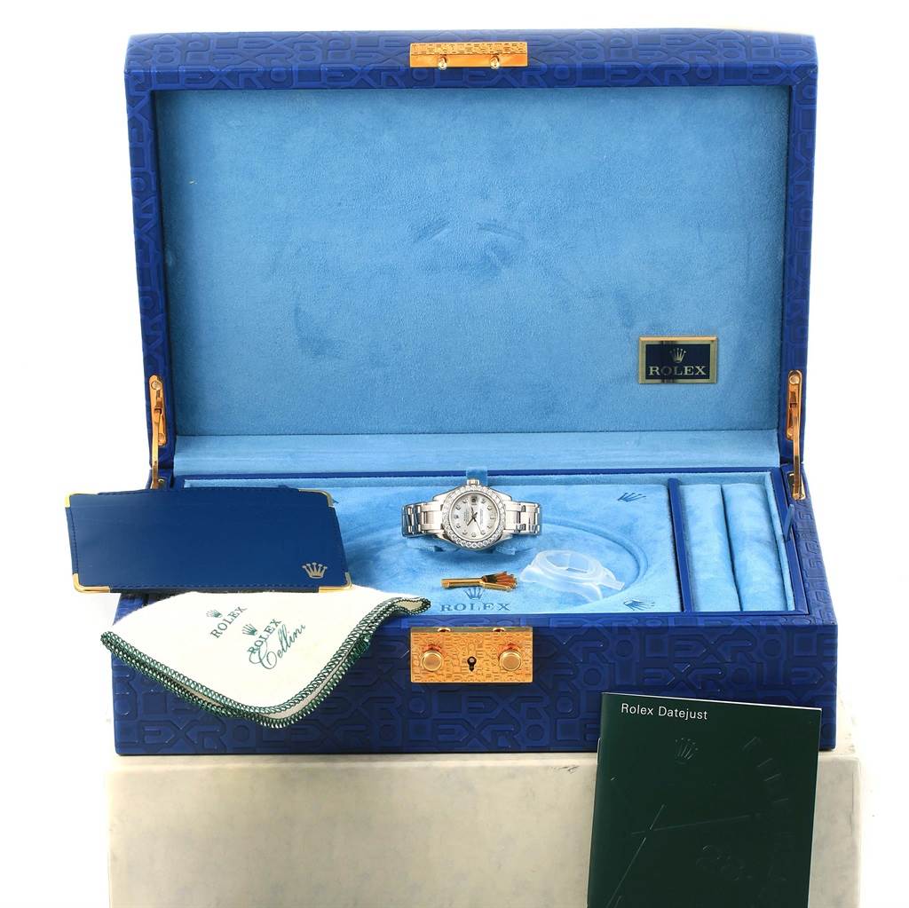 The image shows a Rolex Pearlmaster 80299 Women
s White Gold Mother of Pearl Dial 80299 Women
s White Gold Mother of Pearl Dial watch and its accessories, including its box, cloth, manual, and tags, viewed from a front angle.