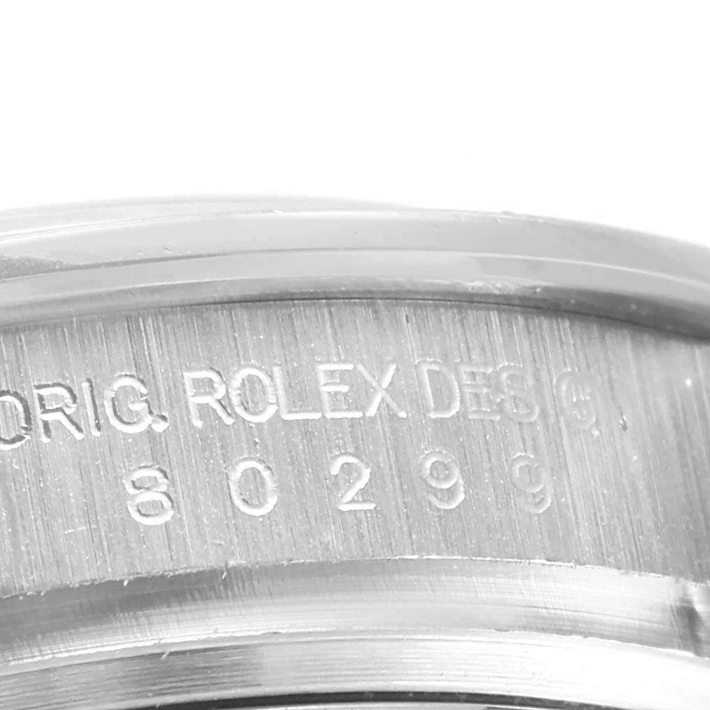 The image shows a close-up of the side casing of the Rolex Pearlmaster 80299 Women
s White Gold Mother of Pearl Dial 80299 Women
s White Gold Mother of Pearl Dial watch, displaying part of the serial number and the engraving "ORIG. ROLEX DESIGN."