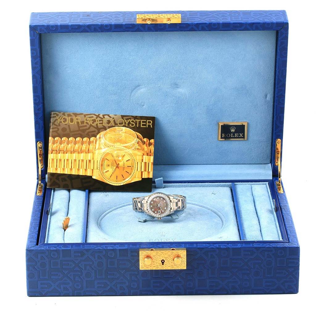The image shows a Rolex Pearlmaster 80299 Women
s White Gold Mother of Pearl Dial 80299 Women
s White Gold Mother of Pearl Dial watch in its open blue box, along with its manual and original packaging.