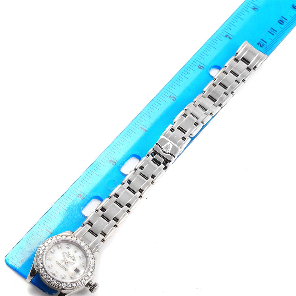 A Rolex Pearlmaster 80299 Women's White Gold Mother of Pearl Dial 80299 Women's White Gold Mother of Pearl Dial watch is shown from a top view, including the full bracelet and watch face, with a blue ruler nearby for scale.