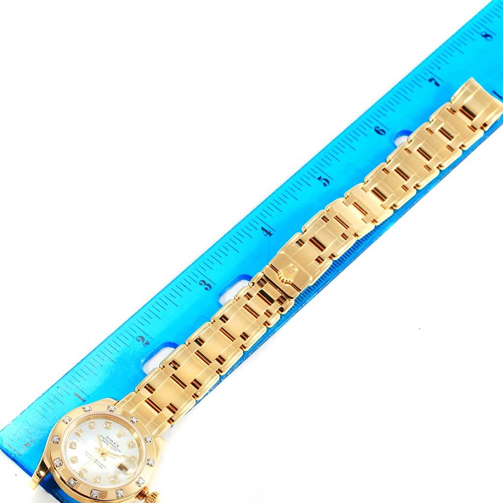 The image shows the face and full bracelet of a Rolex Pearlmaster 80318 Men's Yellow Gold Mother of Pearl Dial 80318 Men's Yellow Gold Mother of Pearl Dial watch lying alongside a blue ruler.