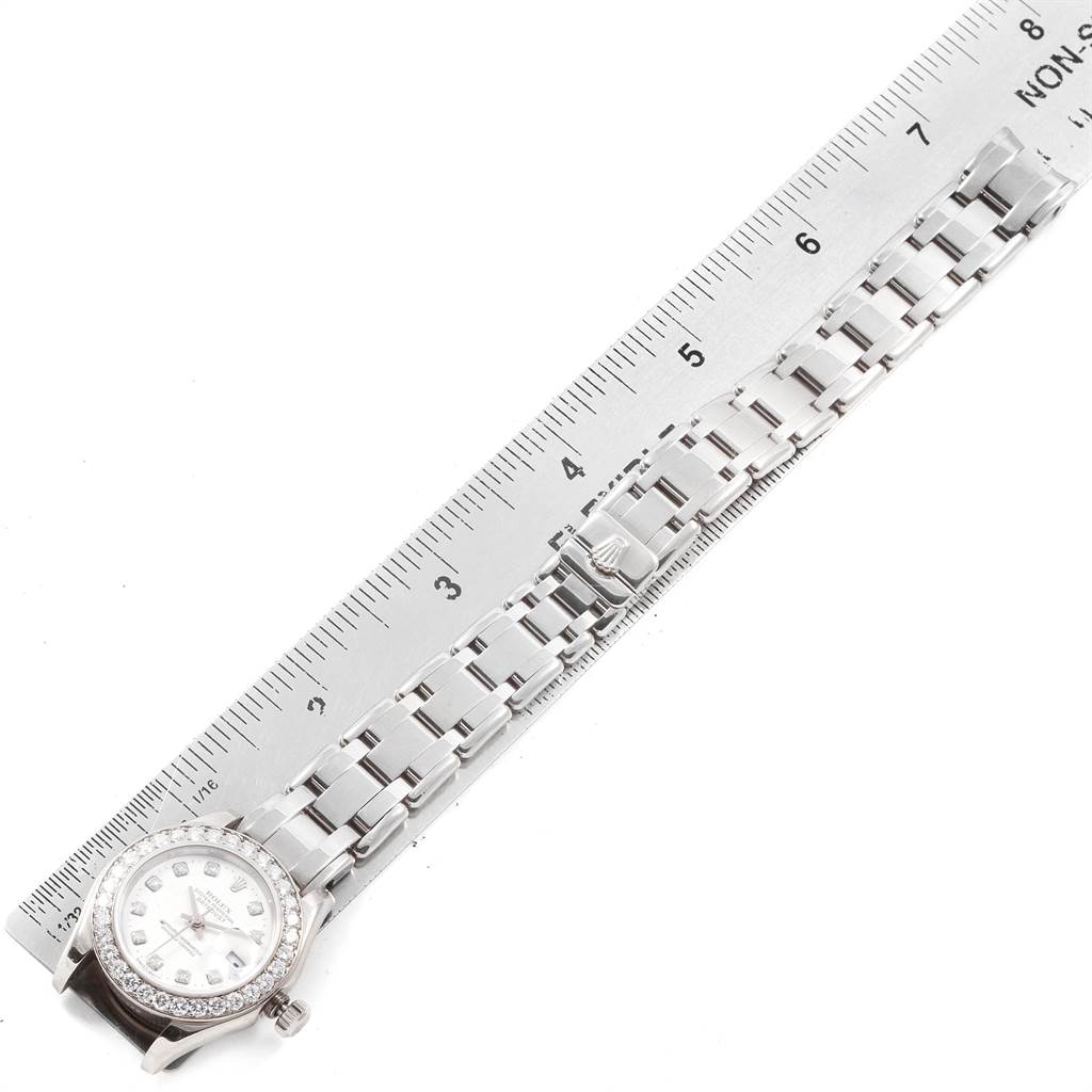 The image shows a Rolex Pearlmaster 80299 Women's White Gold White Dial 80299 Women's White Gold White Dial watch with its bracelet laid flat beside a ruler for size reference.