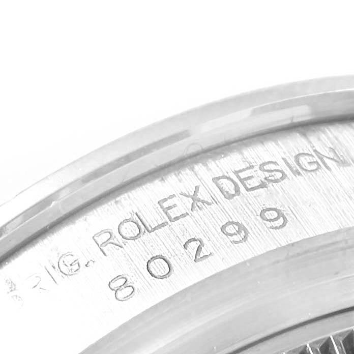 This close-up image of the Rolex Pearlmaster 80299 Women
s White Gold Mother of Pearl Dial 80299 Women
s White Gold Mother of Pearl Dial watch shows part of the case side with engraved text "ROLEX DESIGN 80299."