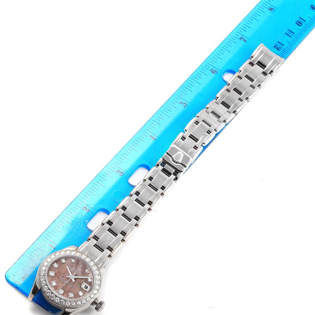 This image shows the Rolex Pearlmaster 80299 Women
s White Gold Mother of Pearl Dial 80299 Women
s White Gold Mother of Pearl Dial watch laid flat against a blue ruler, displaying the watch face, band, and clasp.