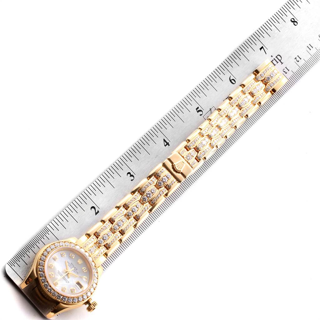 The image shows a Rolex Pearlmaster 69298 Women's Yellow Gold Mother of Pearl Dial 69298 Women's Yellow Gold Mother of Pearl Dial watch placed next to a ruler, capturing the face and part of the bracelet.