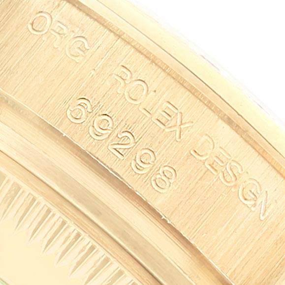 The image shows the engraved serial number and design details on the side of the bezel of the Rolex Pearlmaster 69298 Women's Yellow Gold Mother of Pearl Dial 69298 Women's Yellow Gold Mother of Pearl Dial watch.