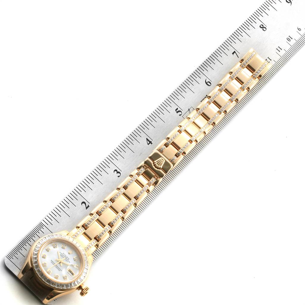The image shows a Rolex Pearlmaster 80308 Women's Yellow Gold Mother of Pearl Dial 80308 Women's Yellow Gold Mother of Pearl Dial watch laid flat beside a ruler, displaying its band and a partial view of the watch face.