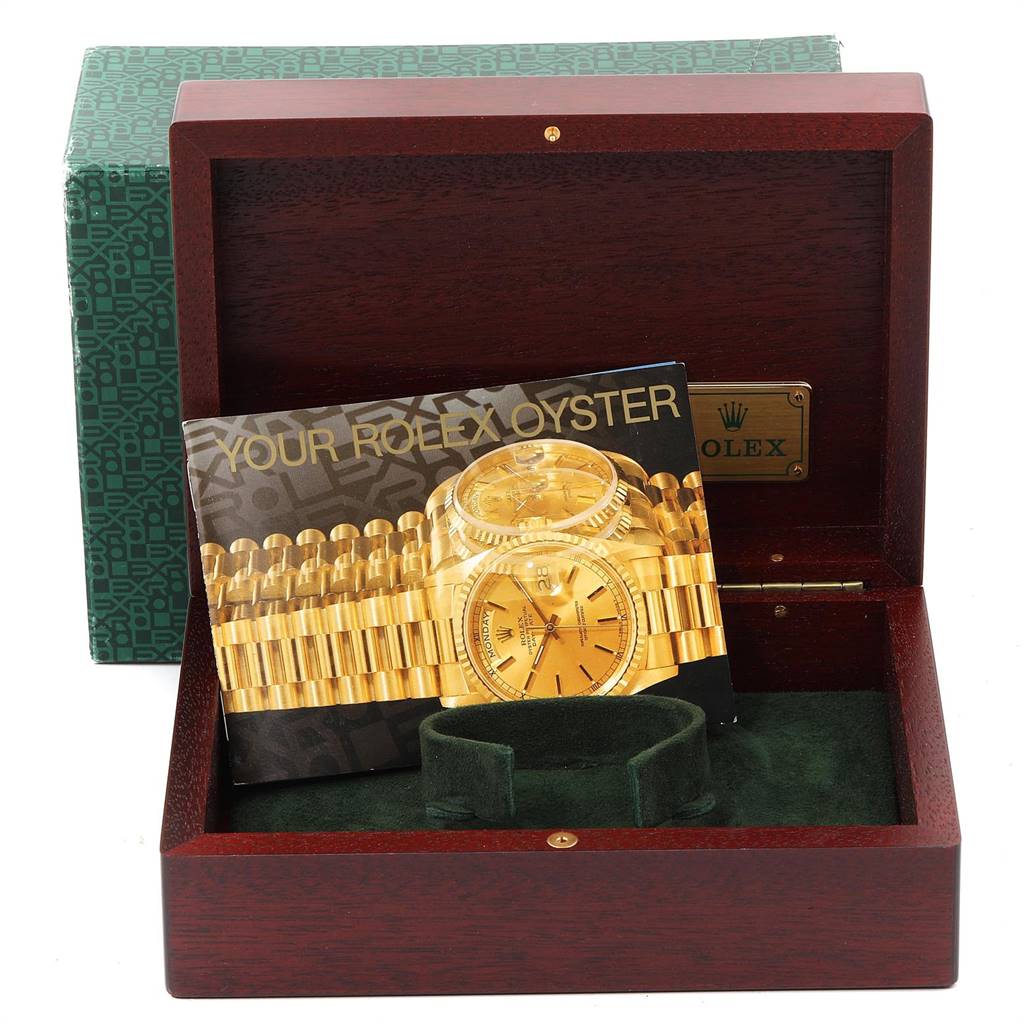 This image shows the packaging and booklet for a Rolex Pearlmaster 69298 Women's Yellow Gold Blue Dial 69298 Women's Yellow Gold Blue Dial, including a green box and a wooden case.