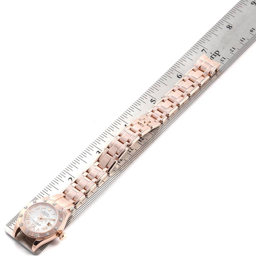 The image shows a Rolex Pearlmaster 80315 Women's Rose Gold Mother of Pearl Dial 80315 Women's Rose Gold Mother of Pearl Dial watch laid flat beside a ruler, highlighting its band and face.