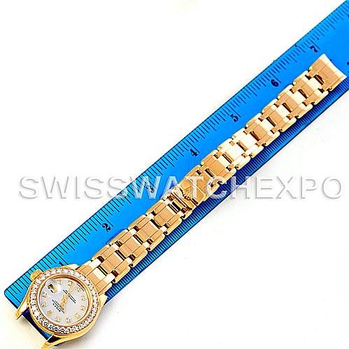 This image shows a Rolex Pearlmaster 69298 Women's Yellow Gold Mother of Pearl Dial 69298 Women's Yellow Gold Mother of Pearl Dial watch at a top-down angle, displaying the watch face, bracelet, and a measuring ruler alongside it.